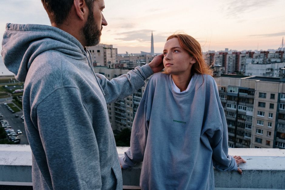 Couple on a rooftop enjoying the urban cityscape at sunset, showcasing romance and togetherness.