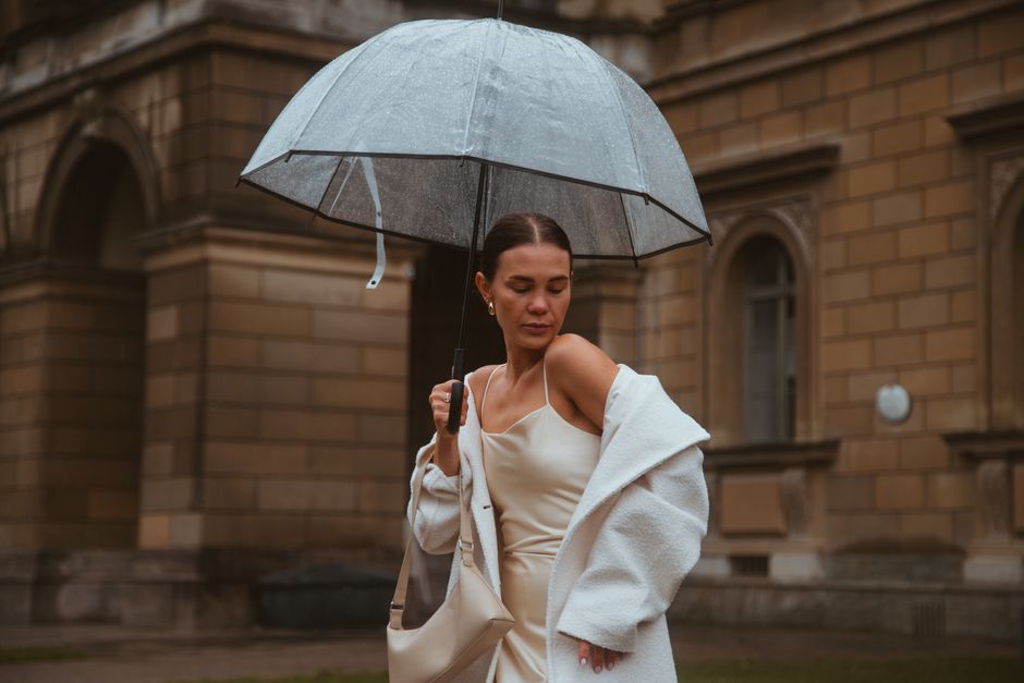 Stylish woman with umbrella on a rainy day in Munich street.
