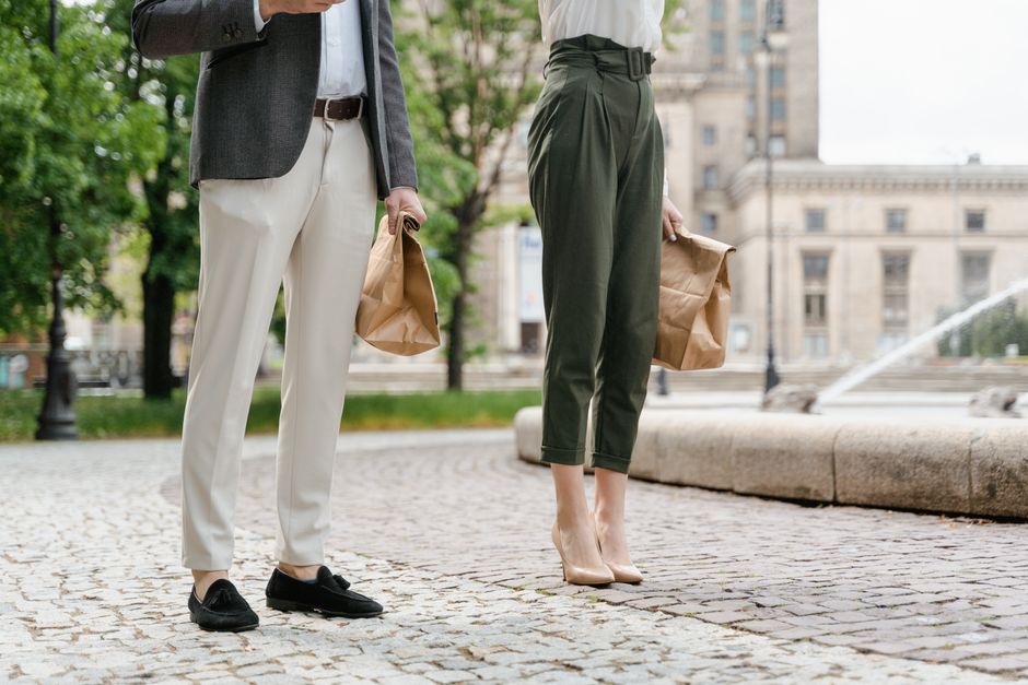 A stylish couple enjoying takeaway food in a bustling city square.