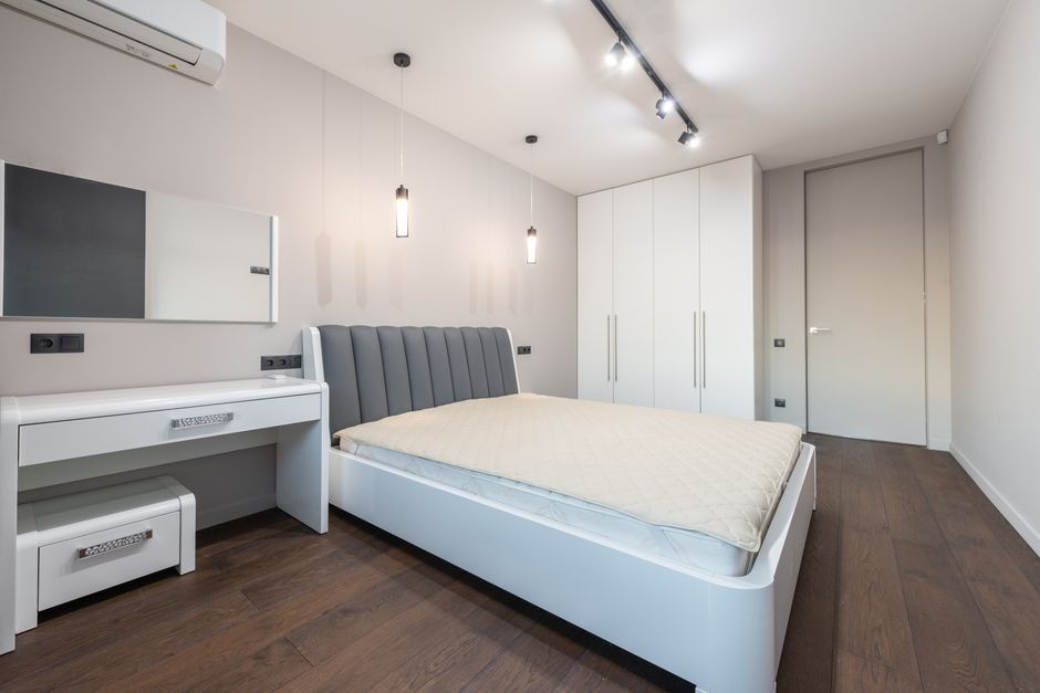 Sleek minimalist bedroom with modern furniture and neutral tones.