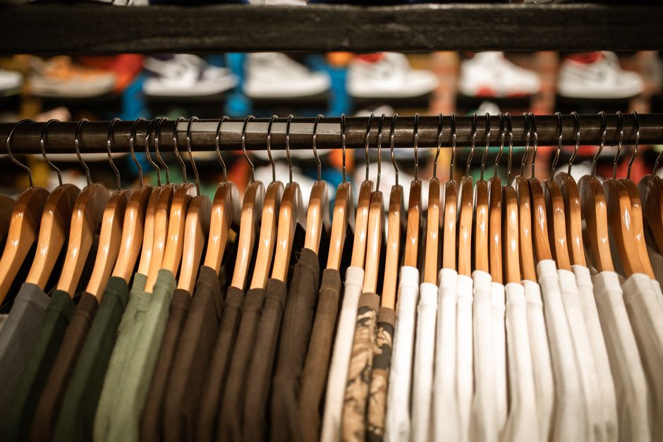 Row of colorful shirts on hangers in a clothing store, offering trendy fashion choices.