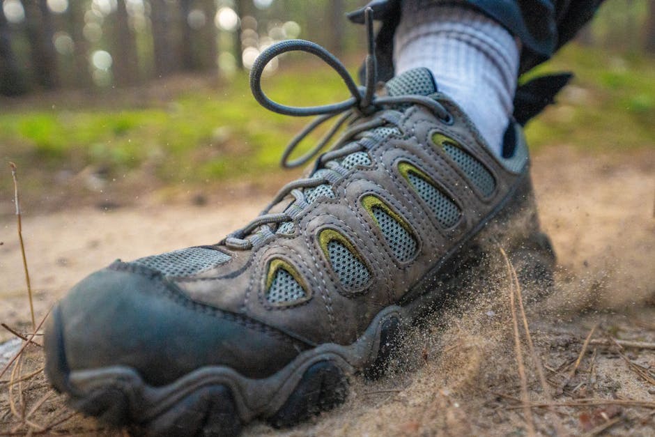 Close-up of a hiking boot kicking up sand on a forest trail, perfect for adventure themes.