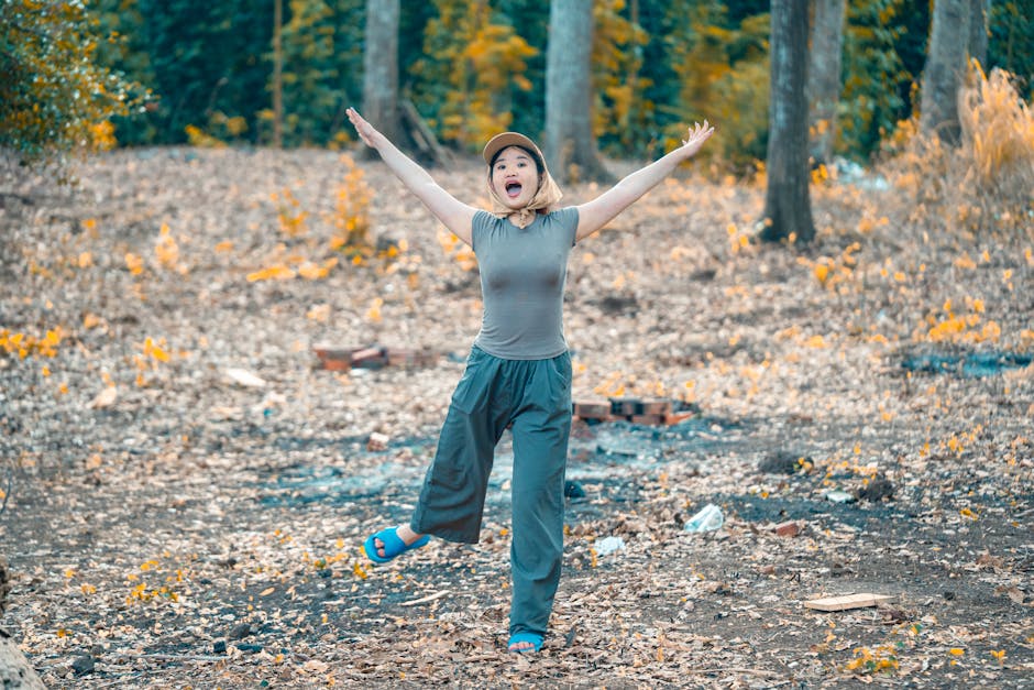 Woman gleefully celebrating in an autumn forest, exuding happiness and joy.