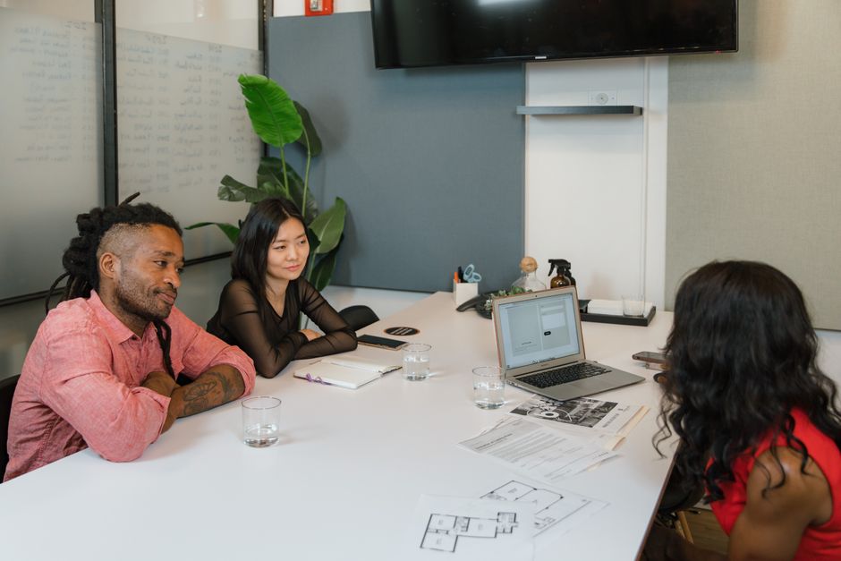 A multicultural team discusses ideas in a modern office setting, fostering collaboration.