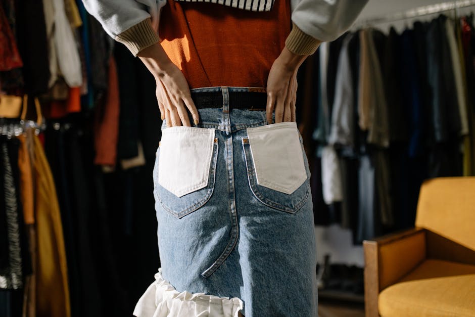 Close-up of denim skirt and hands in pockets, stylish scene indoors.