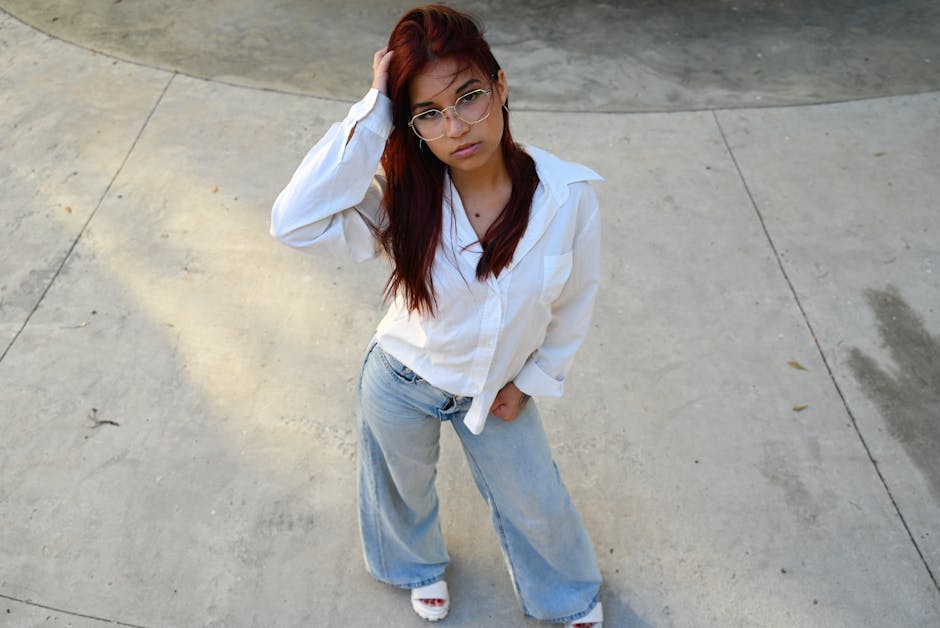 Young woman in casual outfit poses confidently outdoors, showcasing modern fashion and style.